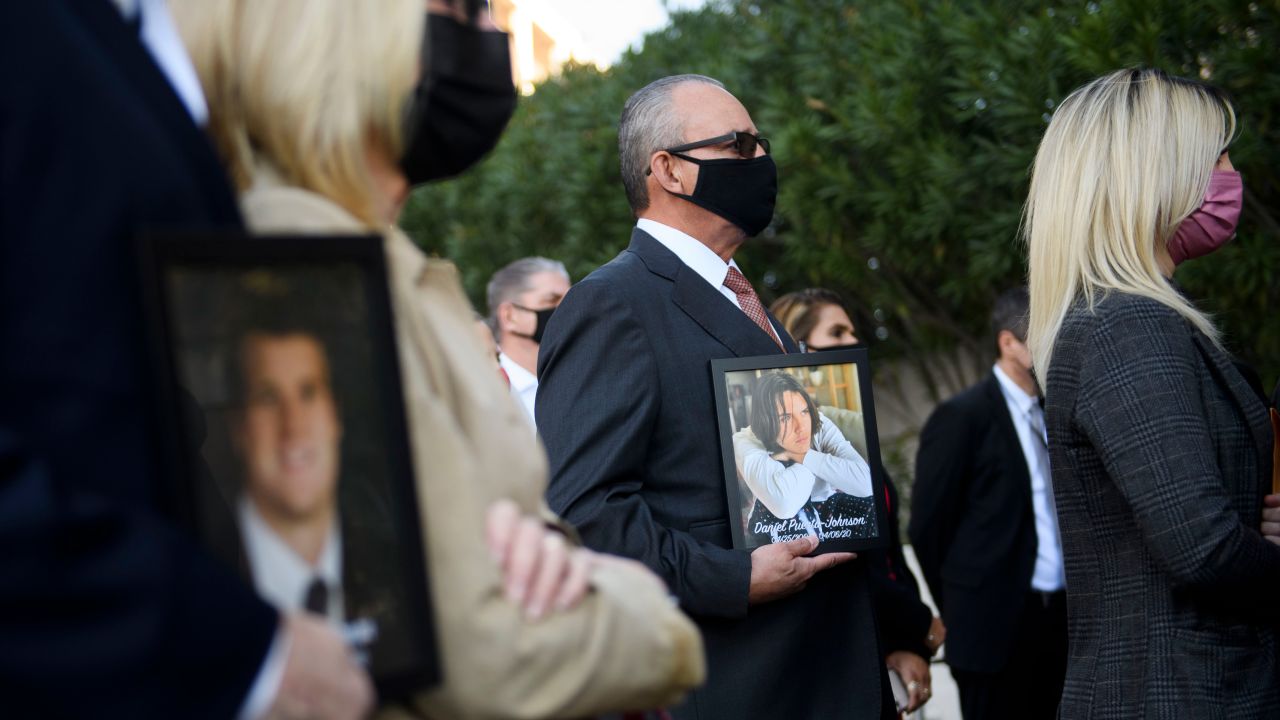 Jaime Puerta, center, holds a portrait of his son, Daniel Puerta-Johnson, who died in April 2020 at the age of 16 from a pill containing fentanyl.