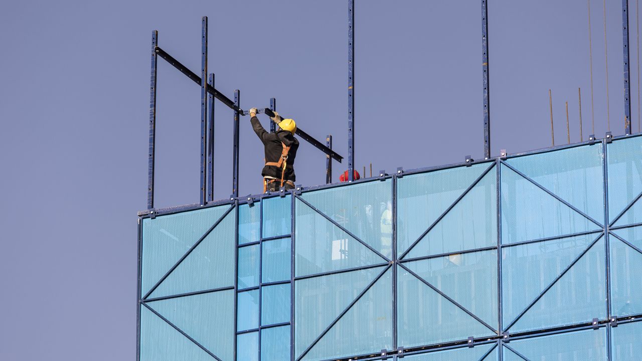 A worker installing safety netting at an apartment block under construction in the Nanchuan area of Xining, Qinghai province, China, on Sept. 28, 2021.