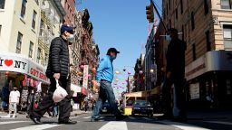 People cross a street in New York's Chinatown on March 21, 2021.
