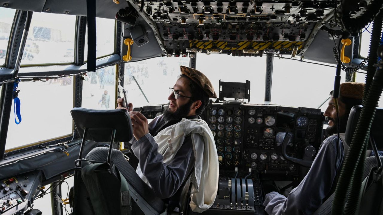 Taliban fighters sit in the cockpit of an Afghan Air Force aircraft at the airport in Kabul on August 31, 2021, after the US pulled its troops out of the country.