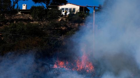 A wildfire raging through Southern California's coastal mountains threatened ranches and rural homes and kept a major highway shut down Wednesday.