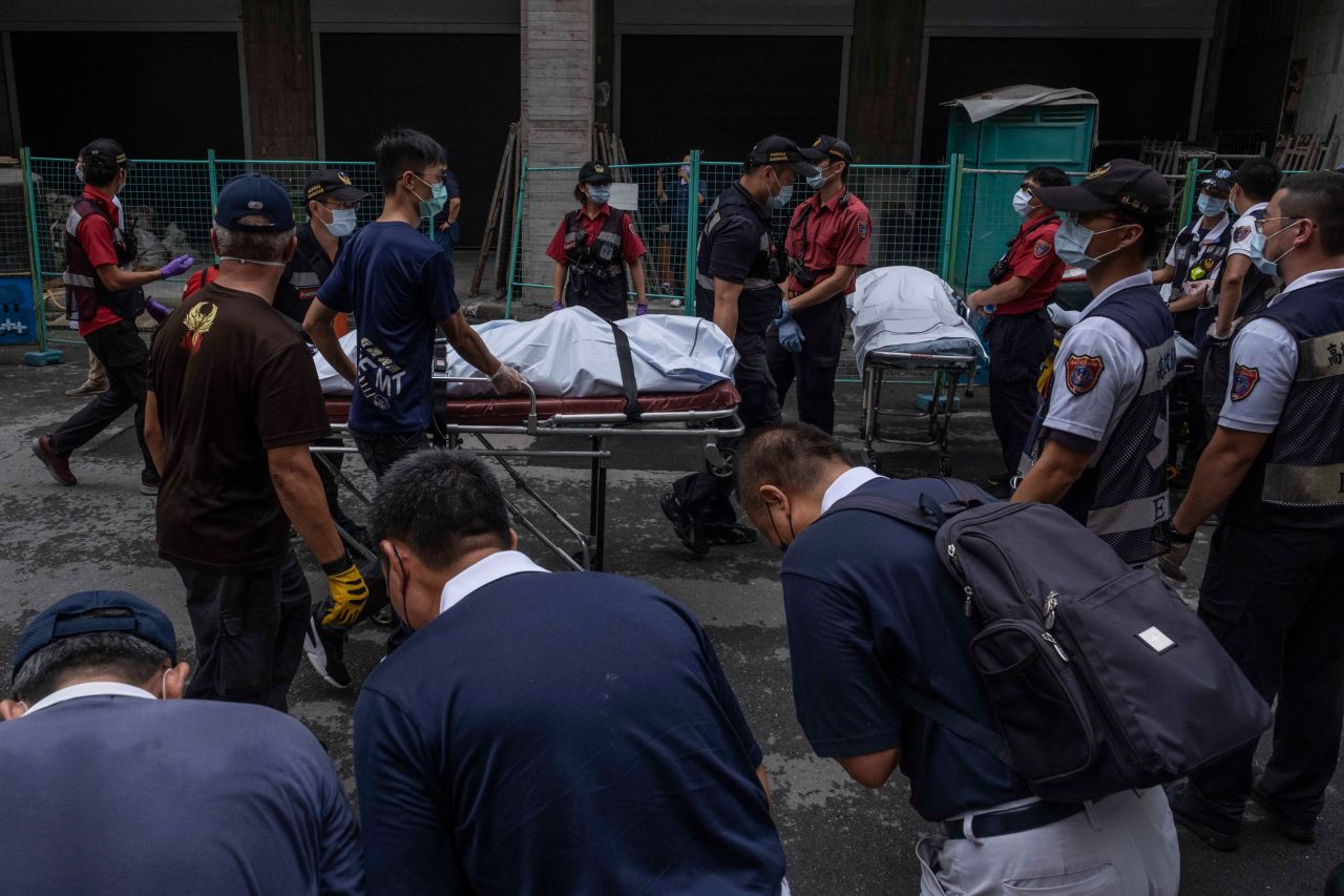Paramedics transport dead bodies after a building fire in Kaohsiung, Taiwan, on Thursday, October 14.