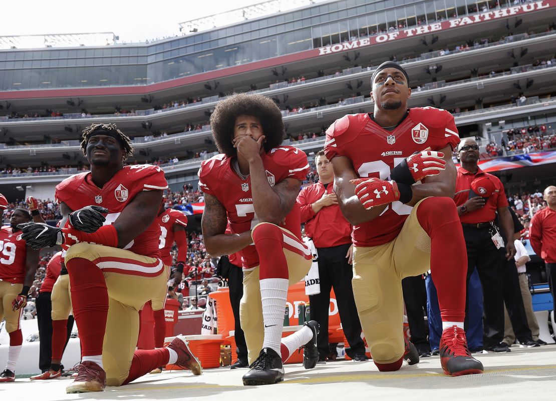 San Francisco 49ers Eli Harold, left, Colin Kaepernick, center, and Eric Reid kneel during the national anthem before the team's game against the Dallas Cowboys.