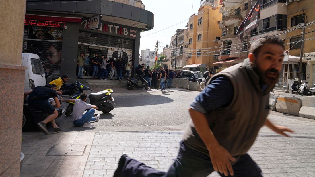 A man runs for cover as gunfire breaks out at a protest in Beirut, Lebanon, on Thursday, October 14.