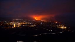TOPSHOT - The Cumbre Vieja volcano, pictured from Tijarafe, spews lava, ash and smoke, on the Canary Island of La Palma, at night on October 10, 2021. - It has been almost three weeks since La Cumbre Vieja began erupting, forcing 6,000 people from their homes as the lava scorched its way across 1,200 acres of land. Earlier on October 9, part of the volcano's cone collapsed, sending new rivers of lava pouring down the slopes towards an industrial zone. (Photo by JORGE GUERRERO / AFP) (Photo by JORGE GUERRERO/AFP via Getty Images)