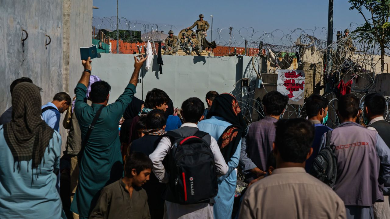 Afghans try to talk to American soldiers to ask to be let into the East Gate of the Airport in Kabul on August 25, 2021.