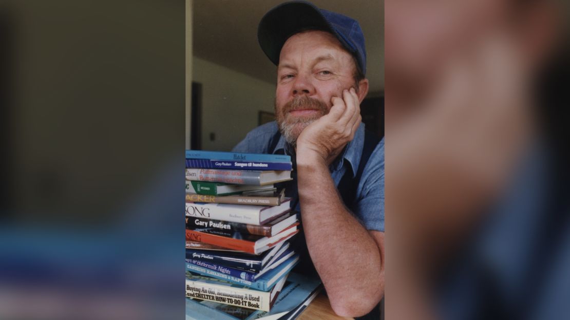 Gary Paulsen, shown with some of his books in 1988,  twice competed in the Iditarod dogsled race in Alaska.