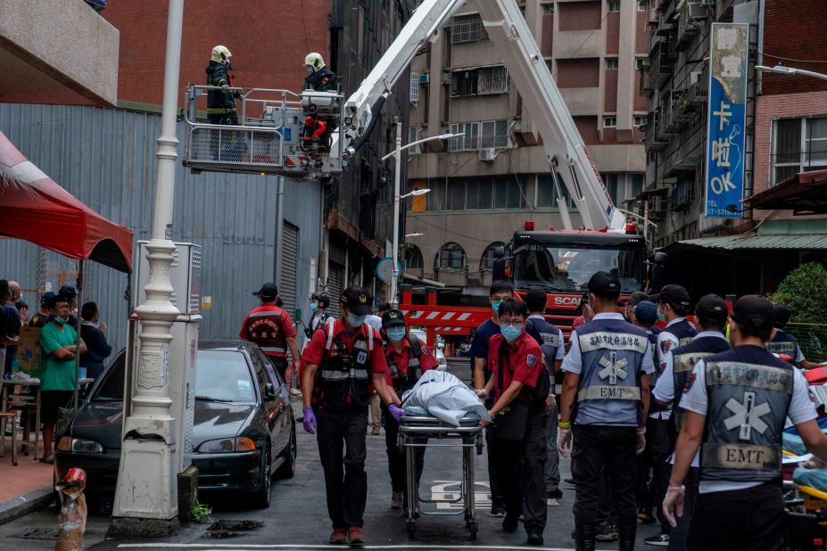 Paramedics transport a dead body from the building on Thursday.