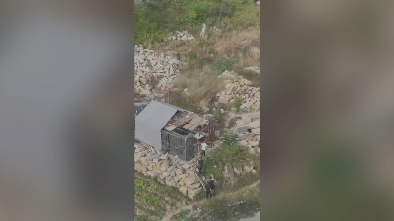 Ou lived in a dilapidated shack, next door to the people he allegedly killed.