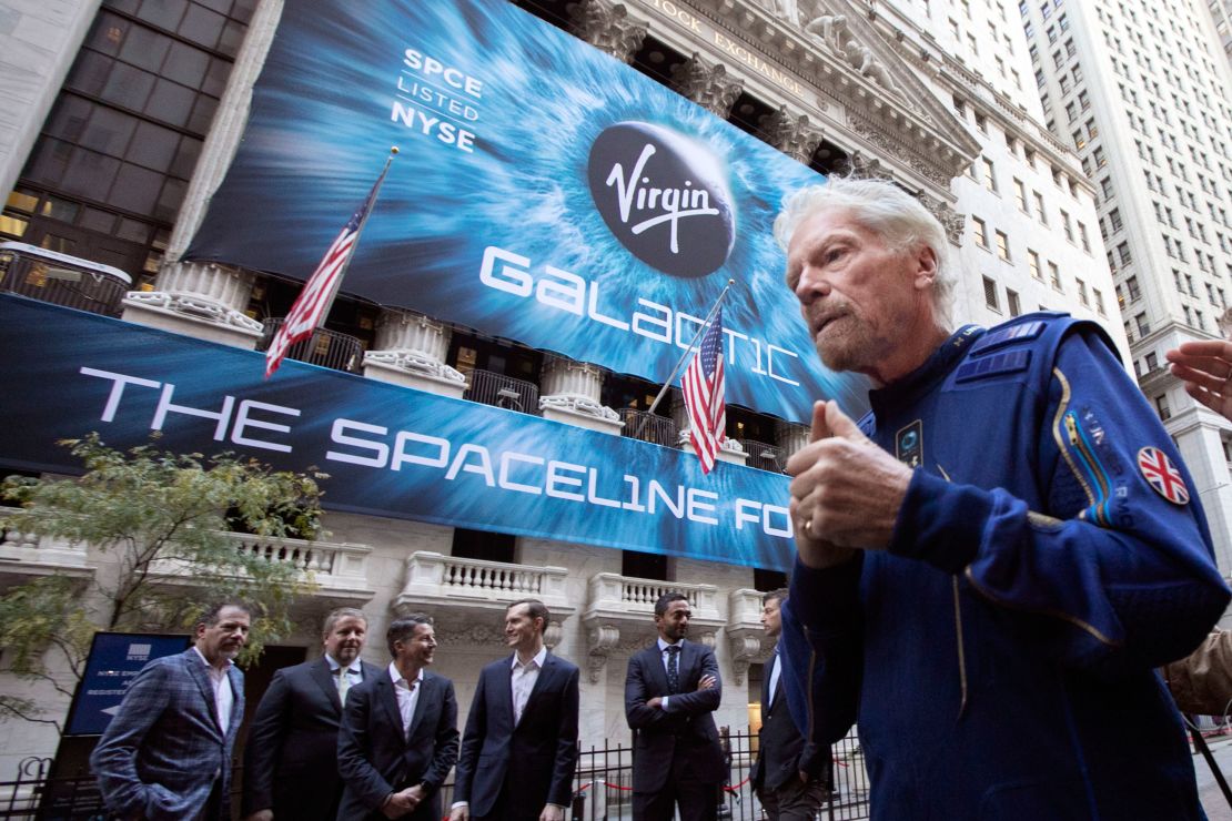 Richard Branson, founder of Virgin Galactic, and company executives gather for photos outside the New York Stock Exchange before his company's IPO.