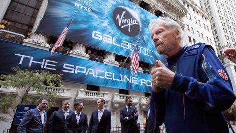 Richard Branson, founder of Virgin Galactic, and company executives gather for photos outside the New York Stock Exchange before his company's IPO.