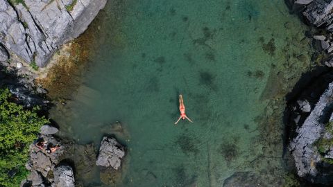Una mujer nada para refrescarse en el lago Xhemas, un pequeño lago natural ubicado en el Parque Nacional Valbona cerca de Dragobi, el 4 de agosto de 2021.