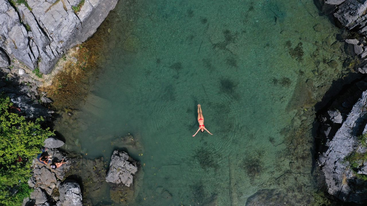 A woman swims in Xhema's Lake in Albania on August 4, 2021.