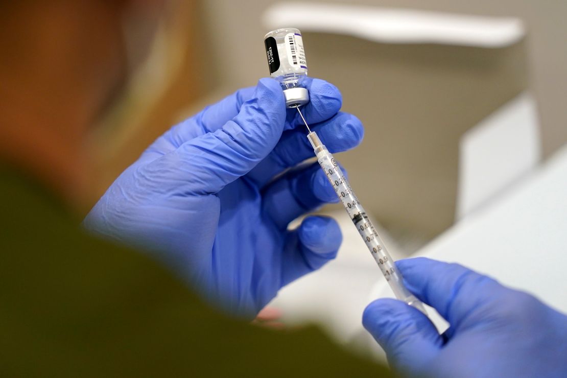 A health care worker fills a syringe with the Pfizer Covid-19 vaccine at Jackson Memorial Hospital on October 5, 2021, in Miami.  