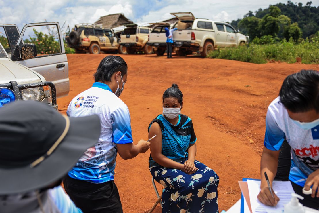 A woman receives a dose of the Pfizer vaccine on October 5, 2021 in the district of Gua Musang, Kelantan, Malaysia.