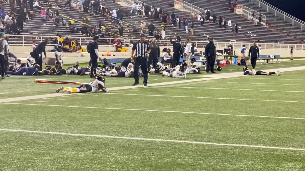 Players lie on the field as they take cover during a football game at Ladd-Peebles Stadium in Mobile, Alabama, on Friday night.