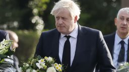 Britain's Prime Minister Boris Johnson carries a floral tribute on arrival at the scene of the fatal stabbing of Conservative British lawmaker David Amess, at Belfairs Methodist Church in Leigh-on-Sea, a district of Southend-on-Sea, in southeast England on October 16, 2021. - Conservative British lawmaker David Amess was killed on Friday after being stabbed "multiple times" during an event in his local constituency in southeast England, in the second death of a UK politician while meeting voters since 2016. Local police did not name Amess but said a man had been arrested "on suspicion (of) murder" after the stabbing in Leigh-on-Sea. (Photo by Tolga Akmen / AFP) (Photo by TOLGA AKMEN/AFP via Getty Images)