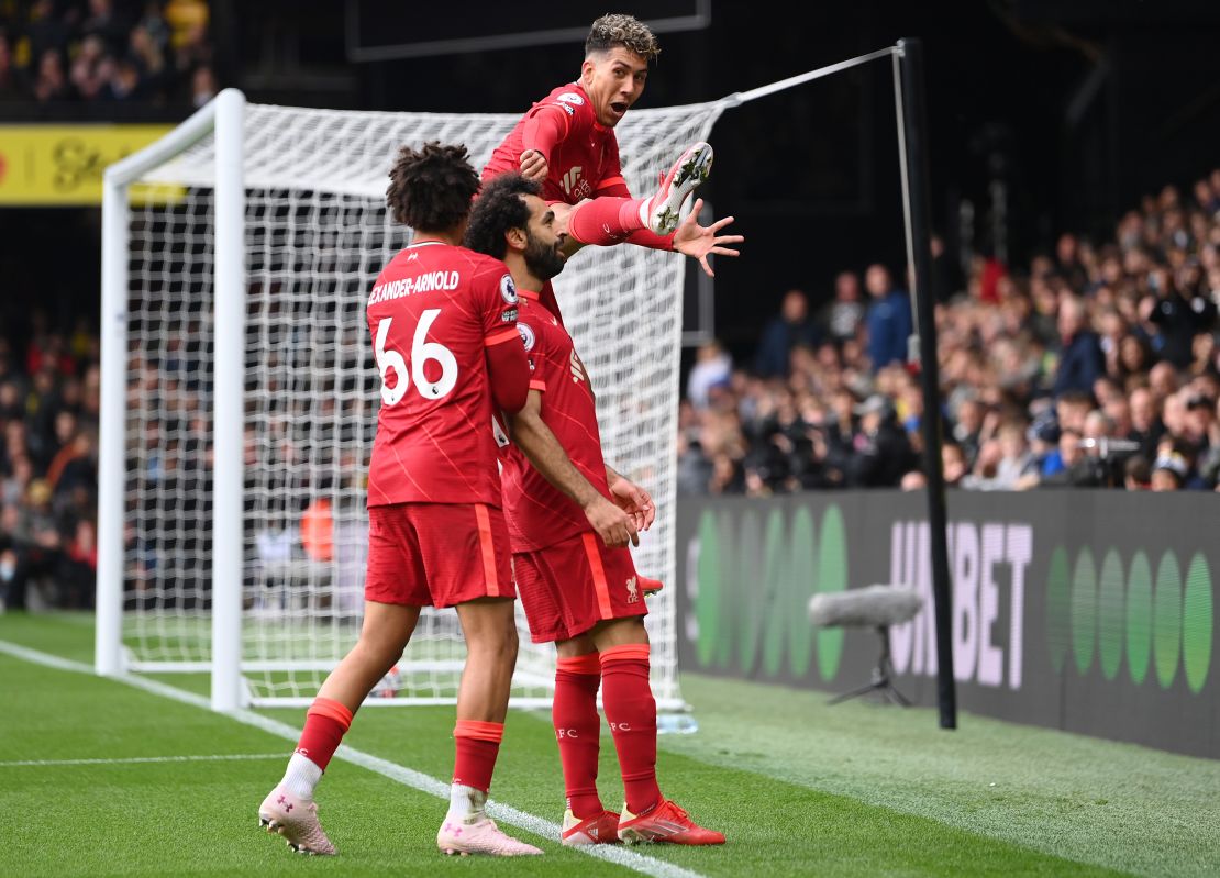 Salah celebrates with teammates Trent Alexander-Arnold and Firmino after scoring against Watford. 