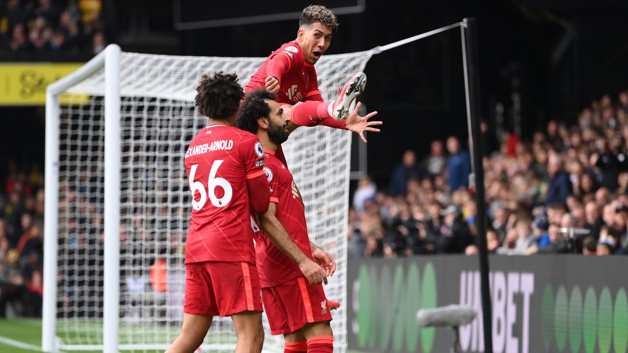 Salah celebrates with teammates Trent Alexander-Arnold and Firmino after scoring against Watford. 