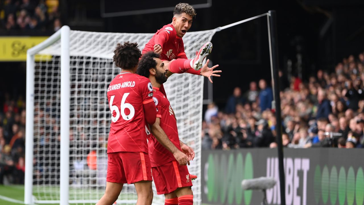 Salah celebrates with teammates Trent Alexander-Arnold and Firmino after scoring against Watford.
