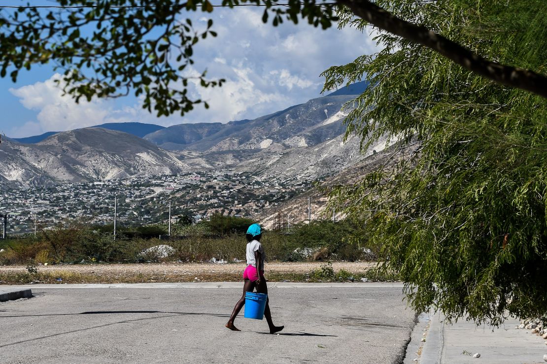 In this file image, a woman carries a bucket of water on the street in Croix des Bouquets, 8 miles northeast of the Haitian capital, Port-au-Prince, on December 30, 2019.