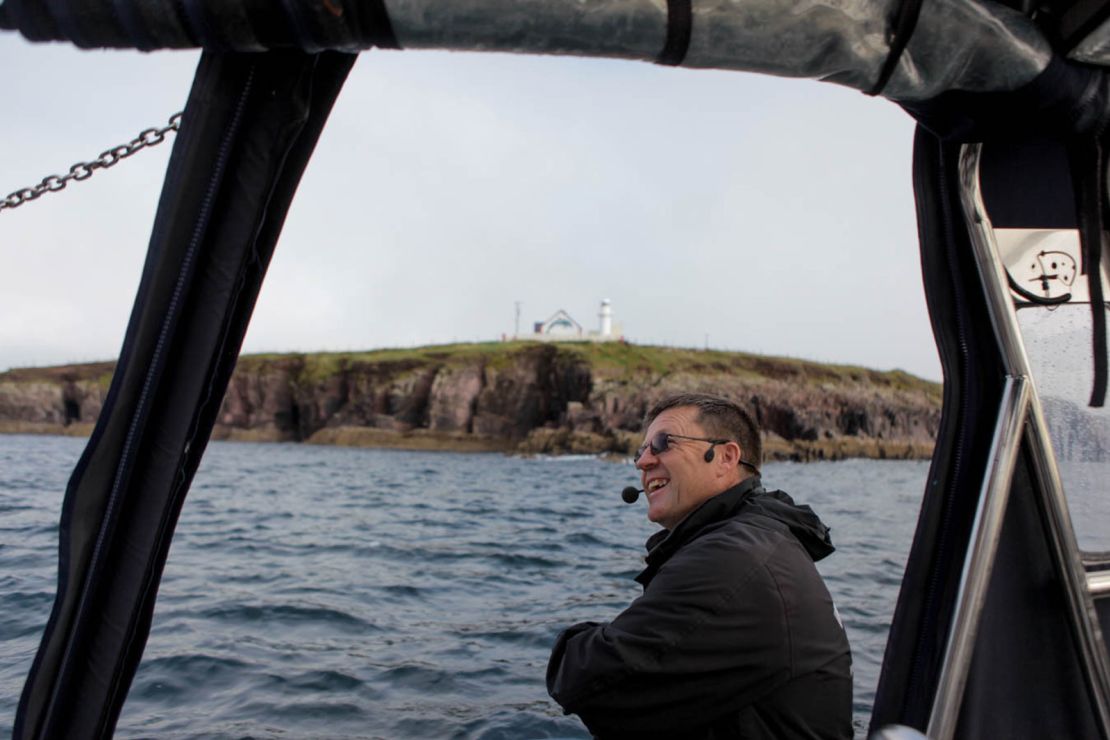 Jimmy Flannery, on his tour boat on Sunday. Behind him is a newly painted mural of Fungie that was painted on the old lighthouse and unveiled on Sunday.