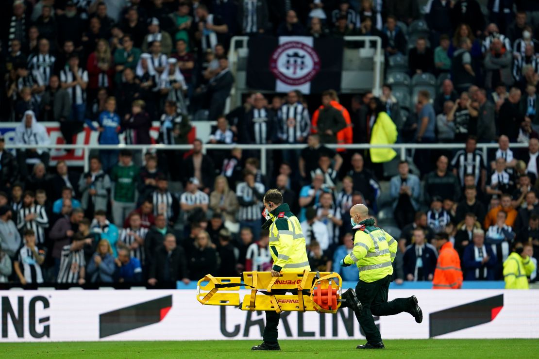 Medics run with a stretcher to treat a person in the crowd during the match between Newcastle and Tottenham Hotspur.