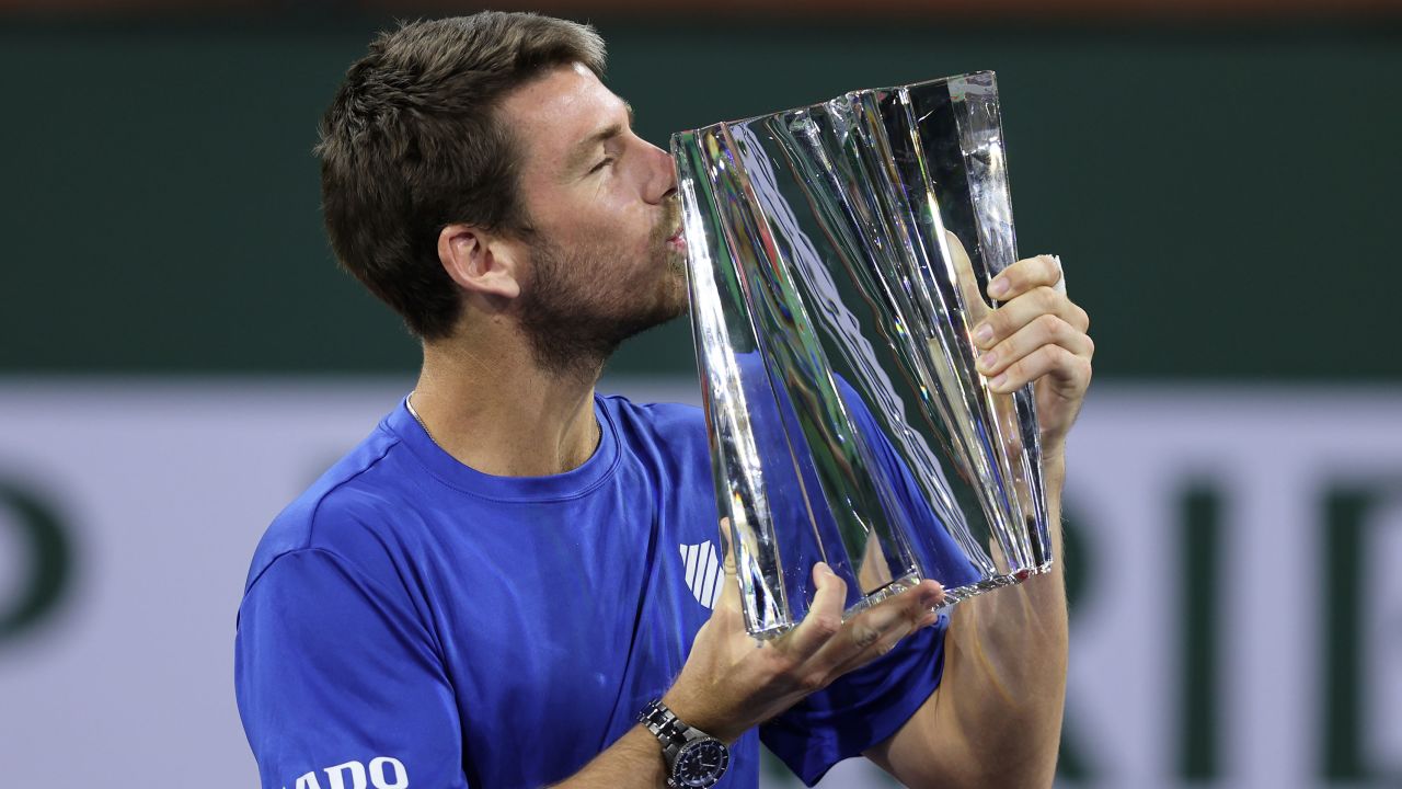 Cameron Norrie of Great Britain kisses his Indian Wells winner's trophy after a three set victory against Nikoloz Basilashvili.