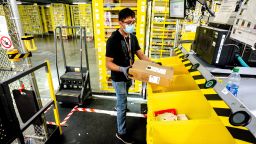 Worker Taiki Okamoto, 20, fulfills an order from a row of bins that are robotically transported to his workstation at Amazon fulfillment center in Eastvale on Tuesday, Aug. 31, 2021. 