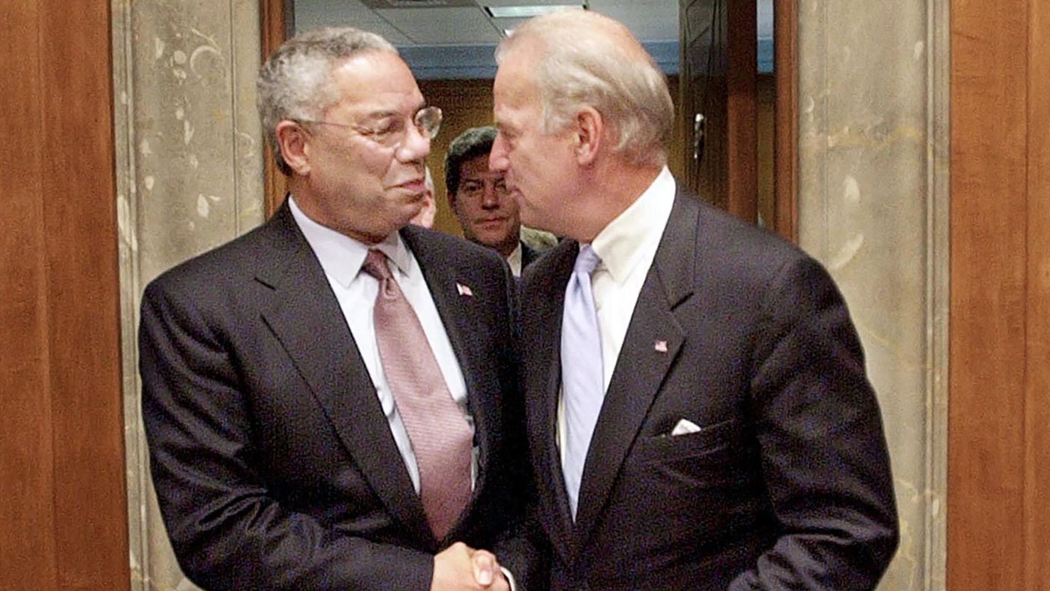 Then-US Secretary of State Colin Powell shakes hands with then-Chairman of the US Senate Foreign Relations Committee Joe Biden on September 26, 2002, on Capitol Hill in Washington, DC.