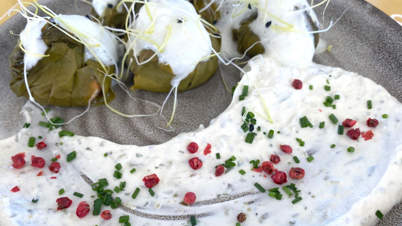 Tiny dolmades stuffed with shrimp and grain are covered with lemon foam and served with a whoosh of tzatziki dip.
