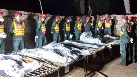 Rescue workers gather near the bodies of the victims in Muzaffargarh, Pakistan, on October 17.