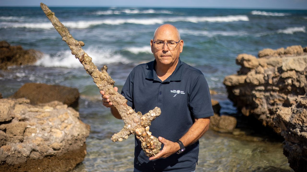 Koby Sharvit, director of the Marine Archaeology Unit of the Israel Antiquities Authority, pictured with the sword.