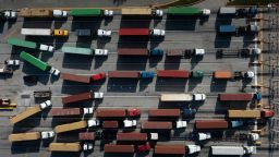 TOPSHOT - In this aerial image, Trucks transport cargo containers at the Port of Baltimore in Baltimore, Maryland, on October 14, 2021. - Closed factories, clogged ports, no truck drivers -- up and down the global supply chain there are problems, raising concerns that it could disrupt the global economic recovery. (Photo by Brendan Smialowski / AFP) (Photo by BRENDAN SMIALOWSKI/AFP via Getty Images)