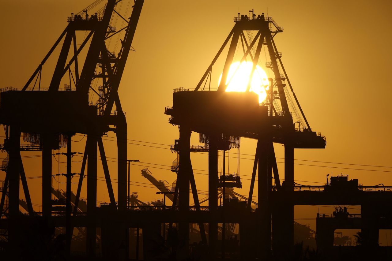 The sun sets on October 14 behind container cranes at the Port of Los Angeles.