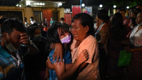 A woman is reunited with her waiting mother outside the Insein Prison following her release in Yangon on October 18, 2021, after authorities announced more than 5,000 people jailed for protesting against a February coup which ousted the civilian government would be released. (Photo by STR / AFP) (Photo by STR/AFP via Getty Images)