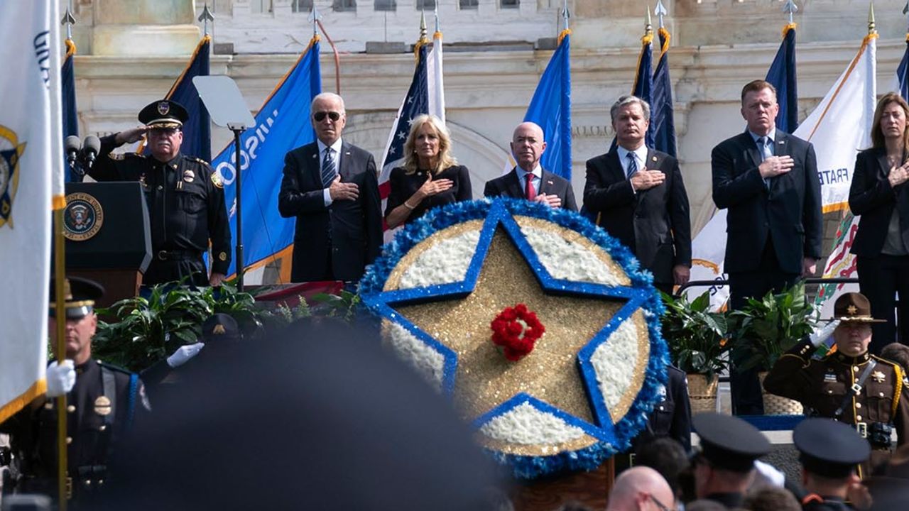 President Joe Biden accompanied by first lady Jill Biden, Secretary of Homeland Security Alejandro Mayorkas, FBI Director Christopher Wray and others listen the national anthem, during a ceremony, honoring fallen law enforcement officers at the 40th annual National Peace Officers' Memorial Service at the US Capitol in Washington, Saturday, October 16, 2021.
