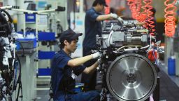 Workers assemble truck engines at a subsidiary factory of the China National Heavy Duty Truck Group in Hangzhou in east China's Zhejiang province, Monday, Oct. 18, 2021.