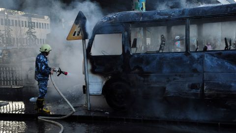A firefighter extinguishes a military bus targeted in a bombing attack in Damascus on Wednesday. 