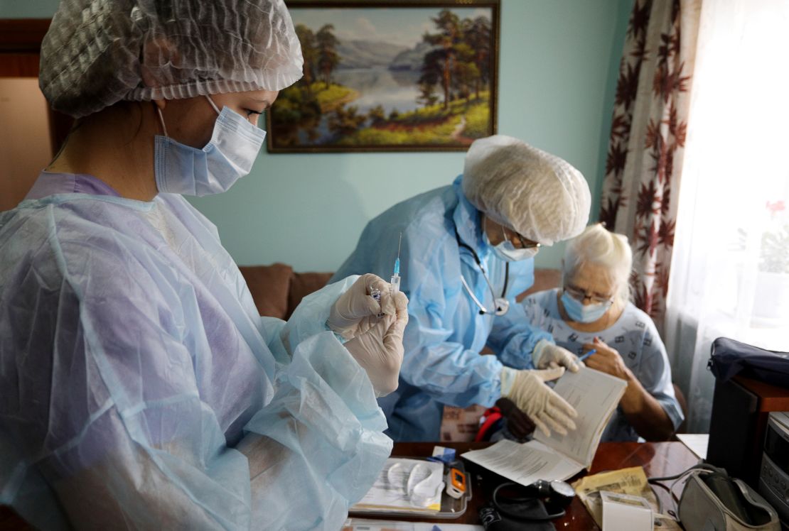 Medical workers vaccinate a patient at home. Russia's vaccine drive has stuttered amid distrust of vaccines and the government's conflicted messaging.