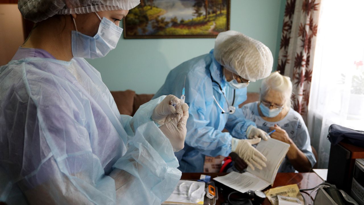 Medical workers vaccinate a patient at home. Russia's vaccine drive has stuttered amid distrust of vaccines and the government's conflicted messaging.