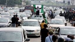 A demonstrator raises a Nigerian flag from a car during a motorcade to mark the one-year anniversary of the EndSARS protest at the Lekki Toll Gate in Lagos, Nigeria October 20, 2021. REUTERS/Temilade Adelaja