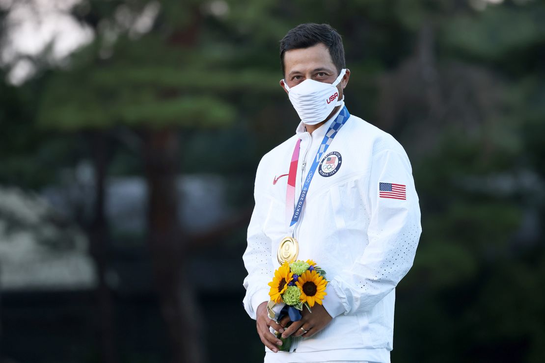 Schauffele stands on the podium while wearing the gold medal after  winning the golf tournament at the 2020 Olympic Games. 
