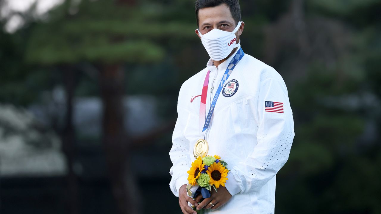 Schauffele stands on the podium while wearing the gold medal after  winning the golf tournament at the 2020 Olympic Games. 
