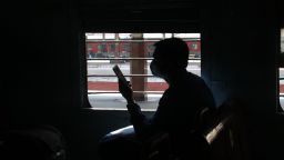 A passenger looks at his mobile phone on a local train in the state of West Bengal in Kolkata, India, on Nov. 11, 2020. 