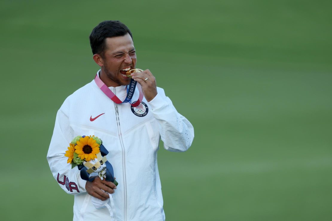 Schauffele celebrates with the gold medal. 