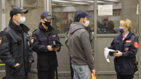 A transport officer issues a fine while checking compliance with pandemic rules, at Pushkinskaya station in the Russian capital.
