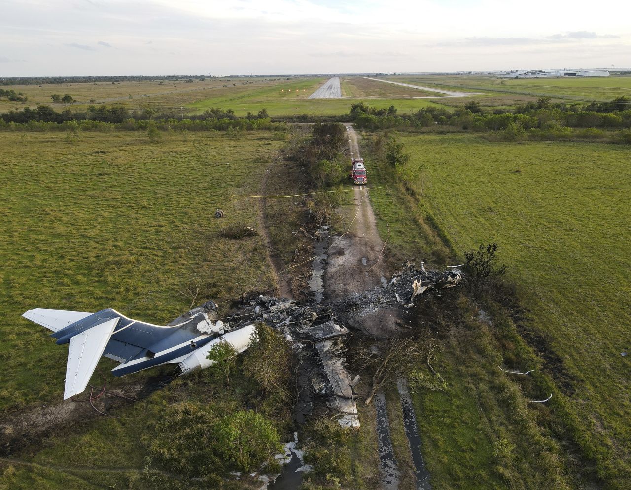 Remnants of an aircraft, which burst into flames when it <a href="https://www.cnn.com/2021/10/19/us/texas-plane-crash/index.html" target="_blank">struck a fence during takeoff</a>, lie in a field near Houston Executive Airport in Brookshire, Texas, on Tuesday, October 19. No major injuries were reported in the crash.
