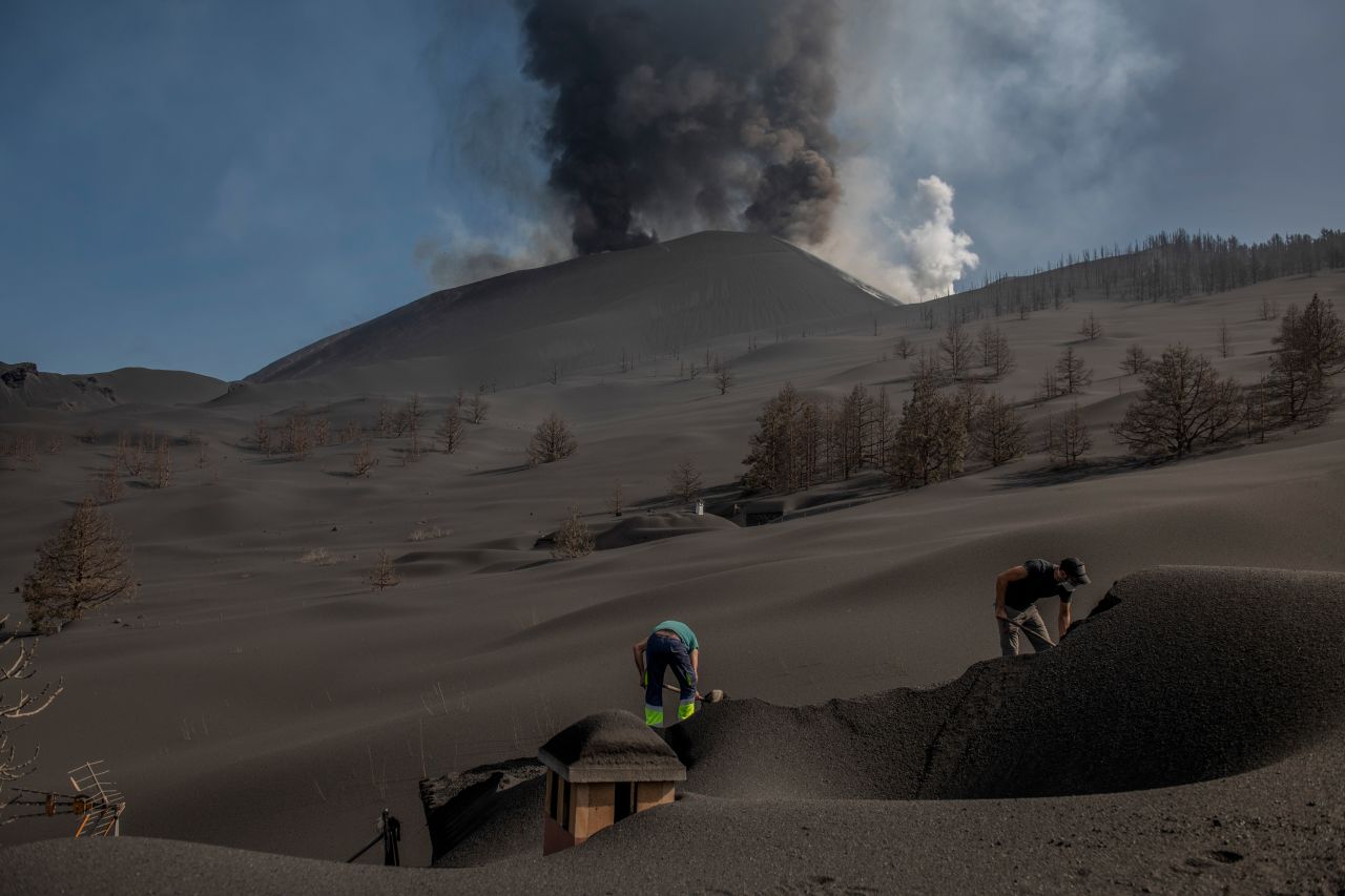People shovel volcanic ash off a house on the Spanish island of La Palma on Thursday, October 14. The <a href="https://www.cnn.com/2021/10/14/europe/la-palma-volcano-intl/index.html" target="_blank">Cumbre Vieja volcano</a> on La Palma has been erupting since September 19.