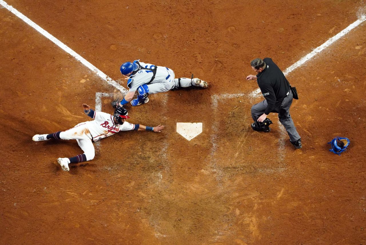 Atlanta Braves left fielder Eddie Rosario slides into home to score ahead of the tag by Los Angeles Dodgers catcher Will Smith during Game 2 of the National League Championship Series in Atlanta, Georgia, on Sunday, October 17. The Braves won the game 5 to 4.